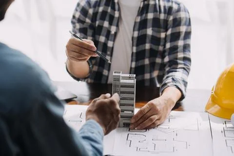 Image of engineering objects on workplace with three partners interacting o.. Foto stock