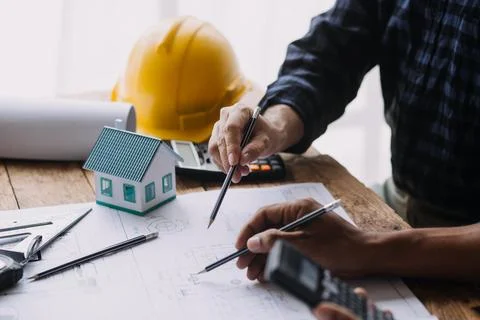 Image of engineering objects on workplace with three partners interacting o.. Stock Photos