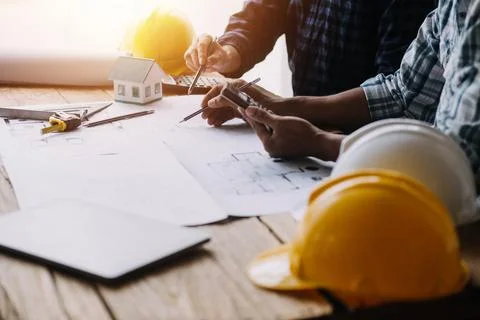 Image of engineering objects on workplace with three partners interacting o.. Foto stock
