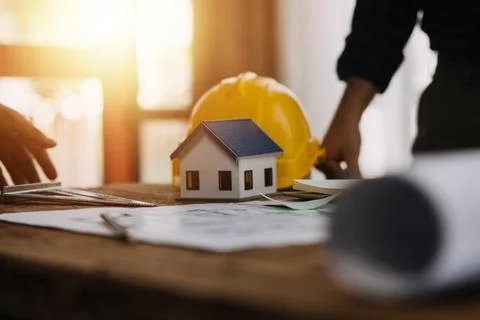 Image of engineering objects on workplace with three partners interacting o.. Foto stock