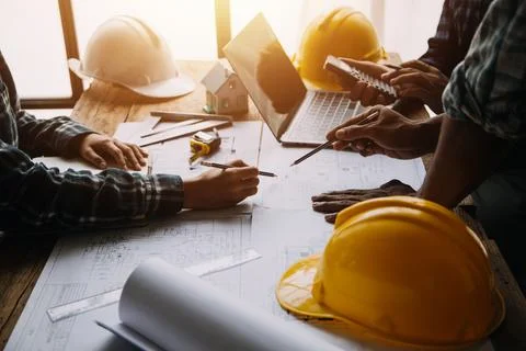 Image of engineering objects on workplace with three partners interacting o.. Foto stock