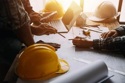 Image of engineering objects on workplace with three partners interacting o.. Foto stock