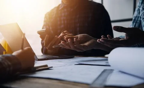Image of engineering objects on workplace with three partners interacting o.. Foto stock