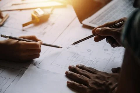 Image of engineering objects on workplace with three partners interacting o.. Foto stock