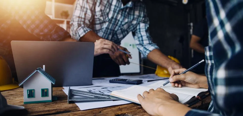 Image of engineering objects on workplace with three partners interacting o.. Foto stock