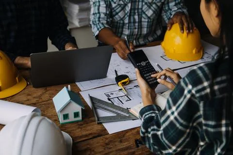 Image of engineering objects on workplace with three partners interacting o.. Foto stock