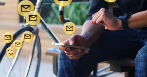Image of envelope icons floating against mid section of man using smartphone in Stock Photos