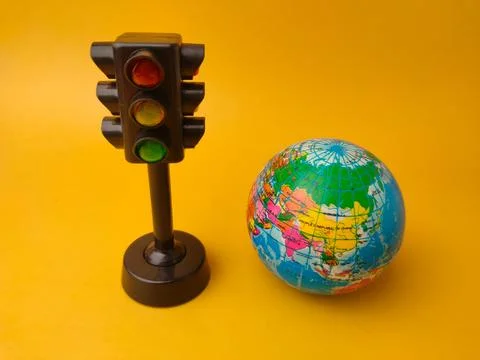 This image features atoy traffic lightalongside asmall globe Stock Photos