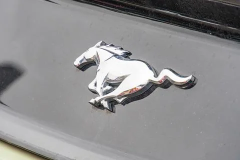 Image features a close-up of Ford Mustang logo on black background, symboli.. Stock Photos