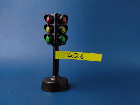 This image features a miniature traffic light toy with a yellow sticky note.. Stock Photos