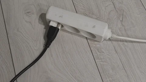 The image features a power strip placed on a wooden floor in a domestic Stock Footage 346539461