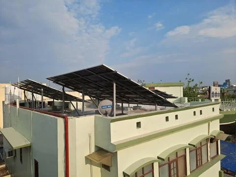 The image features a residential rooftop installation of solar panels. Stock Photos