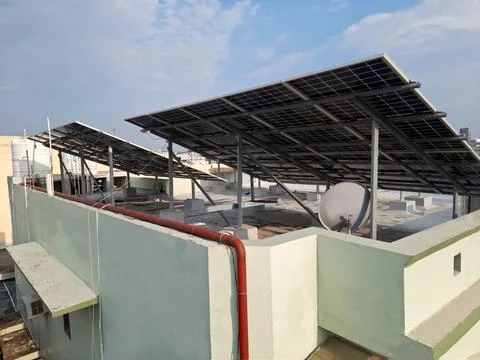 The image features a residential rooftop installation of solar panels. Stock Photos