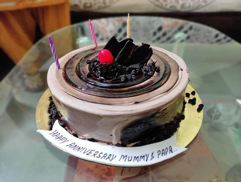The image features a round, chocolate cake with a vanilla base, adorned wit.. Stock Photos
