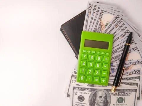 The image features a small, green electronic calculator and a pen on top of.. Stock Photos