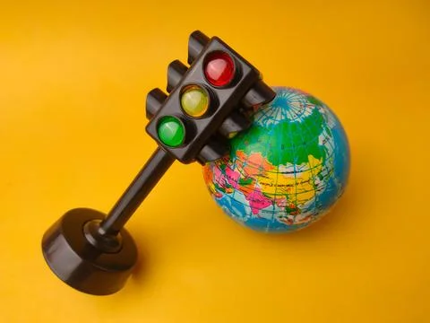 This image features a toy traffic light alongside a small globe Stock Photos