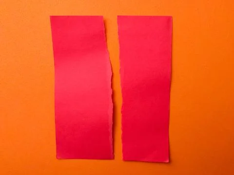 This image features two vertical strips of red paper with torn, rough edges.. Fotos de archivo
