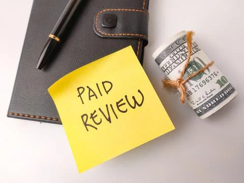 The image features a yellow sticky note with the handwritten text "PAID REV.. Stock Photos