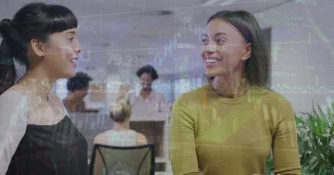 Image of financial data and graphs over diverse female coworkers in office Foto stock