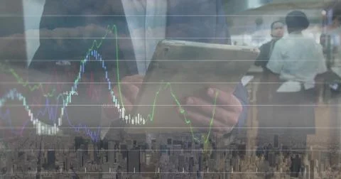 Image of financial data and graphs over caucasian businessman using tablet Stock Photos