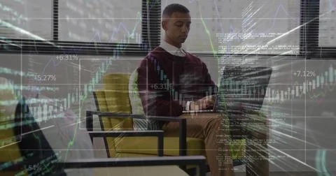 Image of financial data processing against african american man using laptop at Stock Photos
