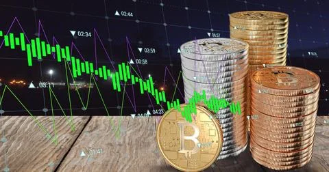 Image of financial data processing over stacks of bitcoins 库存照片