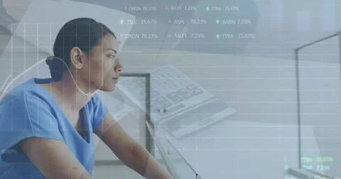 Image of financial data processing over biracial female doctor using computer Stock Photos