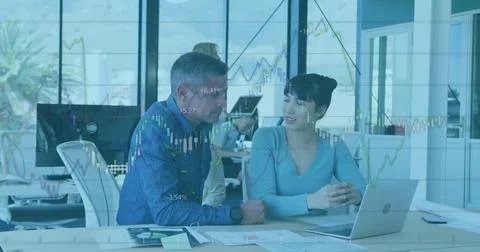 Image of financial data processing over diverse man and woman discussing over a Stock Photos