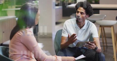 Image of financial data processing over diverse colleagues discussing work in Foto stock
