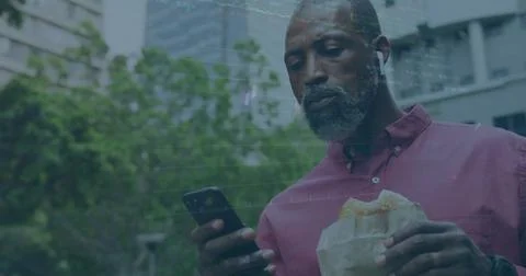 Image of financial data processing over african american man using smartphone Foto stock