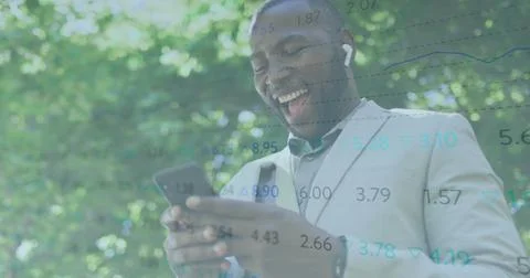 Image of financial data processing over african american man using smartphone Stock Photos