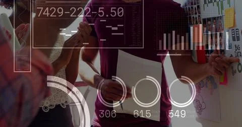 Image of financial data processing over diverse business people working at Stock Photos