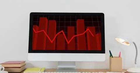 Image of financial data processing with red line over computer screen on desk Stock Photos