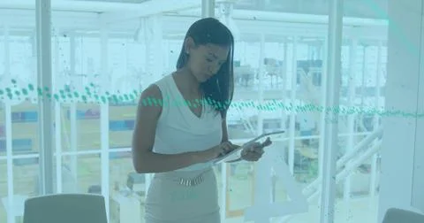 Image of financial graphs and data over woman working in office Stock Photos