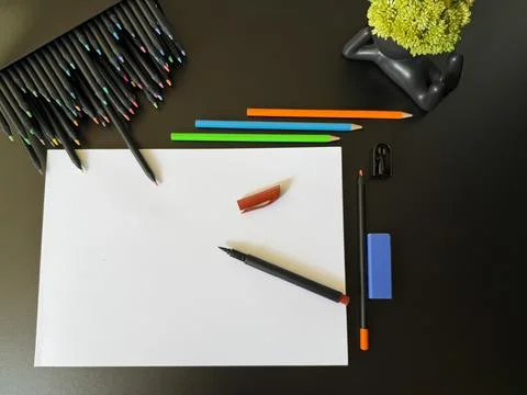 Image formed by a blank sheet surrounded by colorful school accessories. Stock Photos