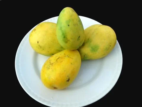 This is the image of four mango which is put in a white plate Stock Photos
