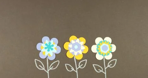 Image frame background of blooming paper flowers on a colored background. Stock Photos