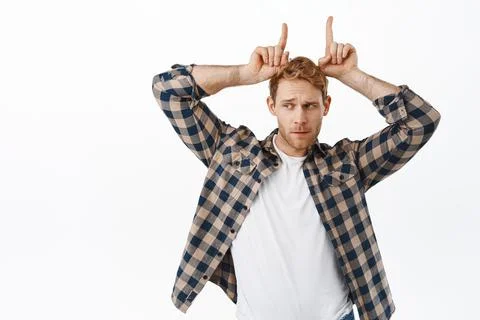 Image of funny handsome man looking sassy aside at logo, showing bull devil Stock Photos