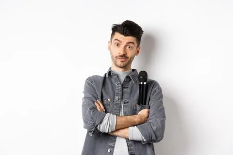 Image of funny male entertainer or singer, holding microphone in pocket of Stock Photos