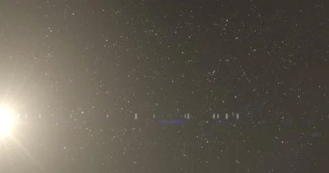 Image of glowing light flickering over twinkling spots on black background Ilustração Stock