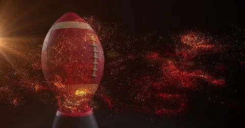 Image of glowing orange particles moving over rugby ball Stock Photos