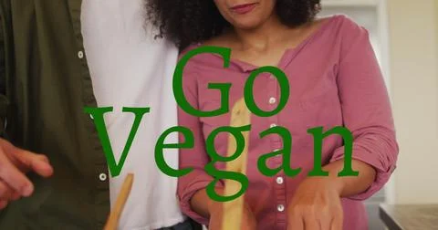 Image of go vegan text over diverse couple cooking Fotos Stock