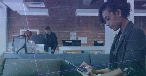 Image of graph and grid pattern over biracial woman scrolling on digital ta.. Stock Photos