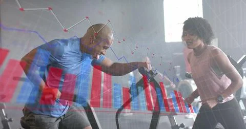 Image of graph processing data over diverse female trainer and man on elliptical Stock Photos