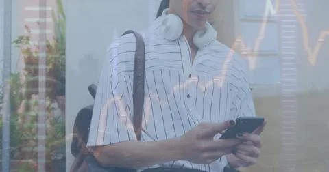 Image of graphs and up arrows over biracial man with travel bag scrolling on Stock Photos