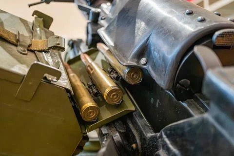 Image of a green storage container filled with metallic rifle rounds, along.. Stock Photos