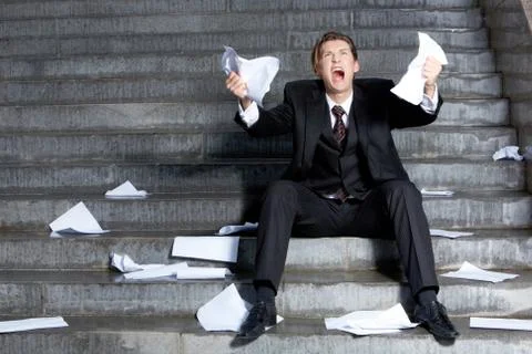 Image of grieving businessman crying with papers in hands Stock Photos