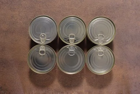 Image of a group of closed tin cans with a key to open them. Foto stock