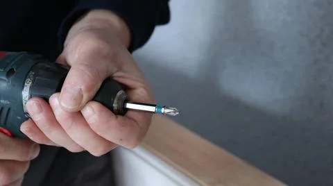 Image of hands with a drill on an empty backdrop Stock Photos