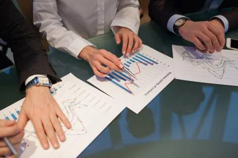 Image of hands pointing at business document during discussion at meeting. Fotos Stock